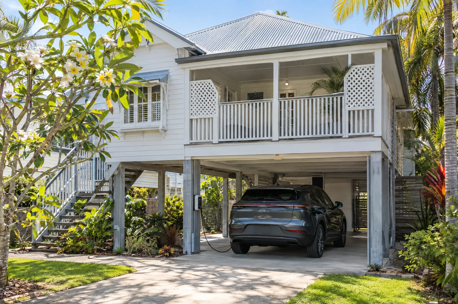 Electric SUV charging under a high-set Queenslander house from a post-mounted charger
